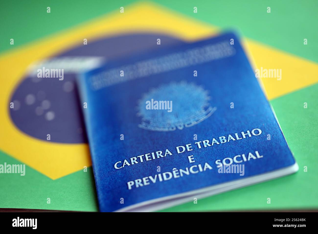 Tessera di lavoro brasiliana e libro blu di sicurezza sociale sulla bandiera della Repubblica Federativa del Brasile primo piano. Tessera di lavoro brasiliana e blu di sicurezza sociale Foto Stock