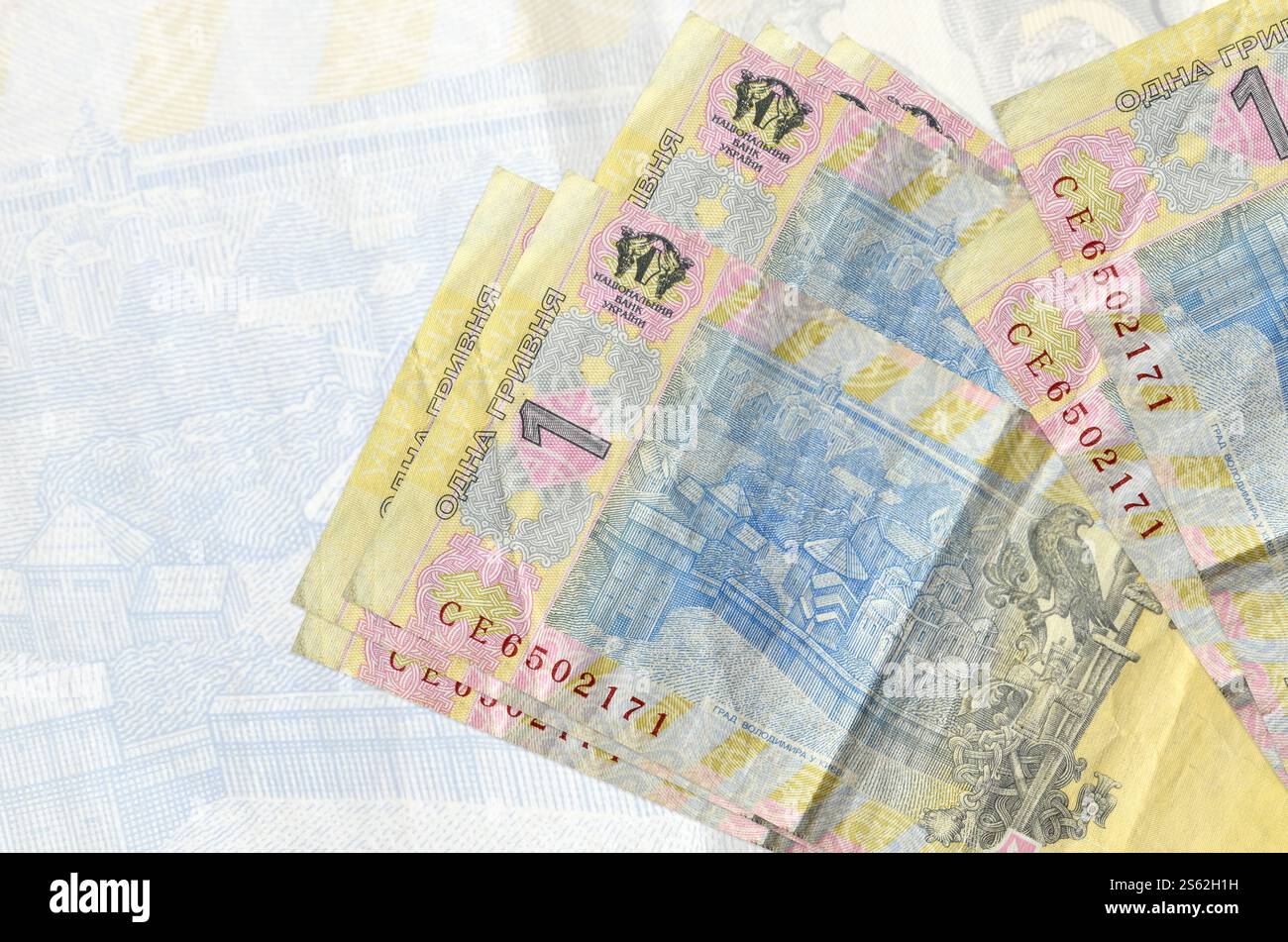 1 le banconote ucraine in grivna si trovano in una pila sullo sfondo di una grande banconota semi-trasparente. Presentazione astratta della moneta nazionale. Concetto di business. Foto Stock
