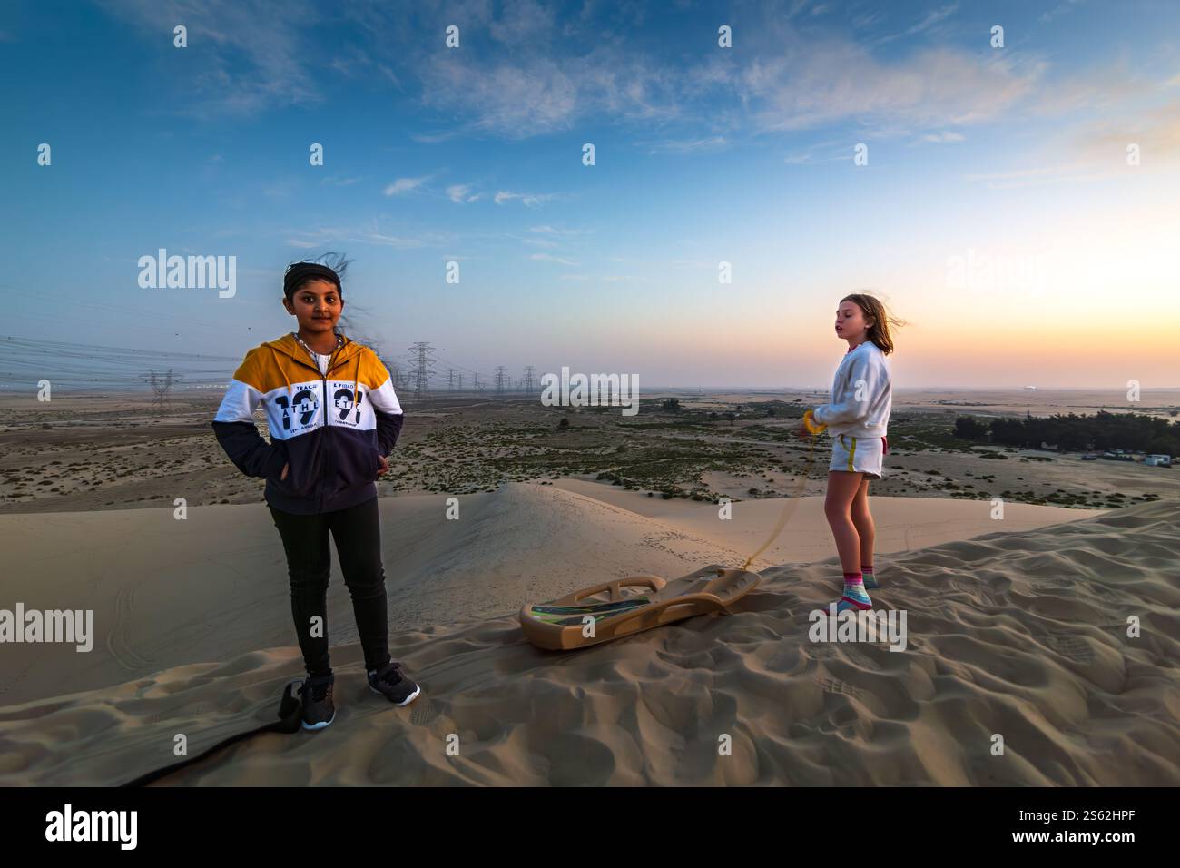 Due ragazze in un paesaggio desertico ad al Hofuf, Arabia Saudita. Messa a fuoco selettiva e profondità di campo. Foto Stock
