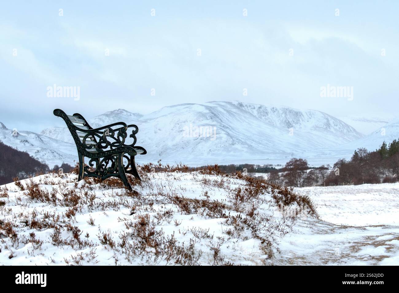 Panchina pubblica sopra Newtonmore nella neve invernale Foto Stock