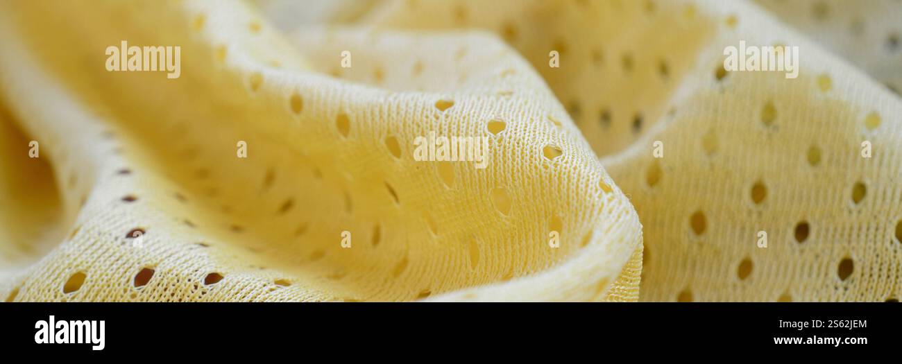 Sfondo in tessuto sportivo in rete gialla. Maglia da calcio colore giallo tessuto abbigliamento sportivo. Poroso traspirante Foto Stock