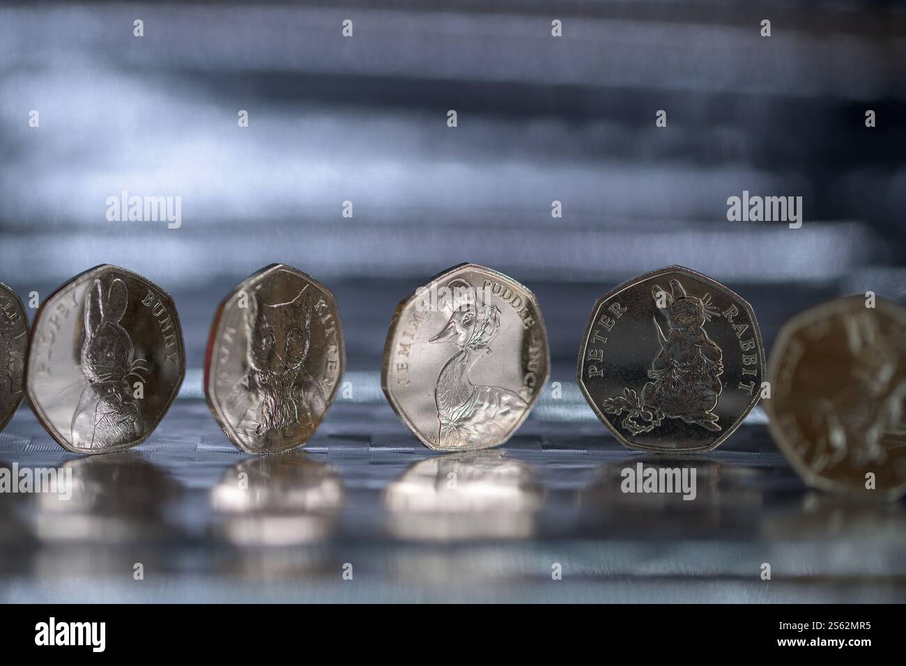 Sterling Coins, set Beatrix Potter da 50p, monete da 50 pence, posizionate su una superficie riflettente Foto Stock