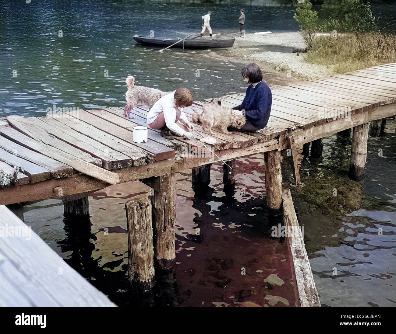 Bambini che giocano la pesca sul molo Gran Bretagna 1960 Foto Stock