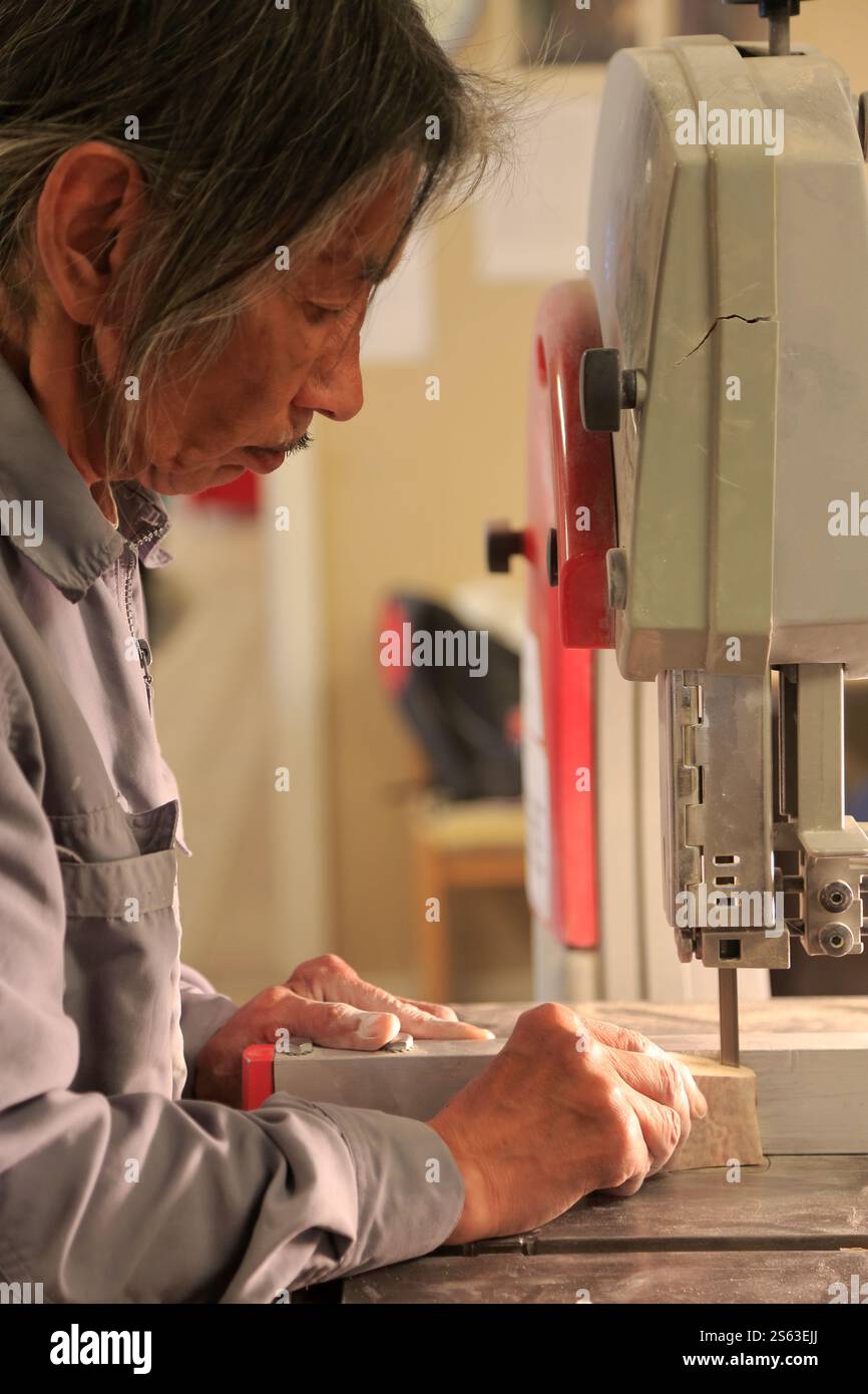 Un artigiano Inuit che sega un pezzo di osso di balena per realizzare un osso intagliato in un laboratorio di artigianato nel comune di Sisimiut.Sisimiut.Qeqqata. Groenlandia Foto Stock Un artigiano Inuit che sega un pezzo di osso di balena per realizzare un osso intagliato in un laboratorio di artigianato nel comune di Sisimiut.Sisimiut.Qeqqata. Groenlandia Foto Stock