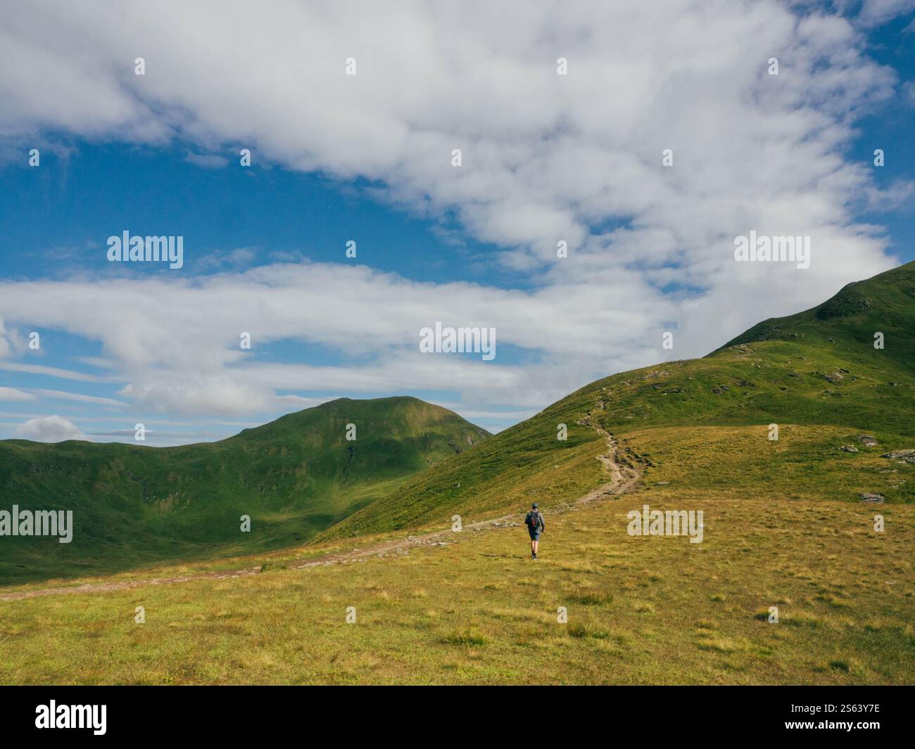 Uomo che cammina Ben Lawers in Scozia in un giorno d'estate Foto Stock