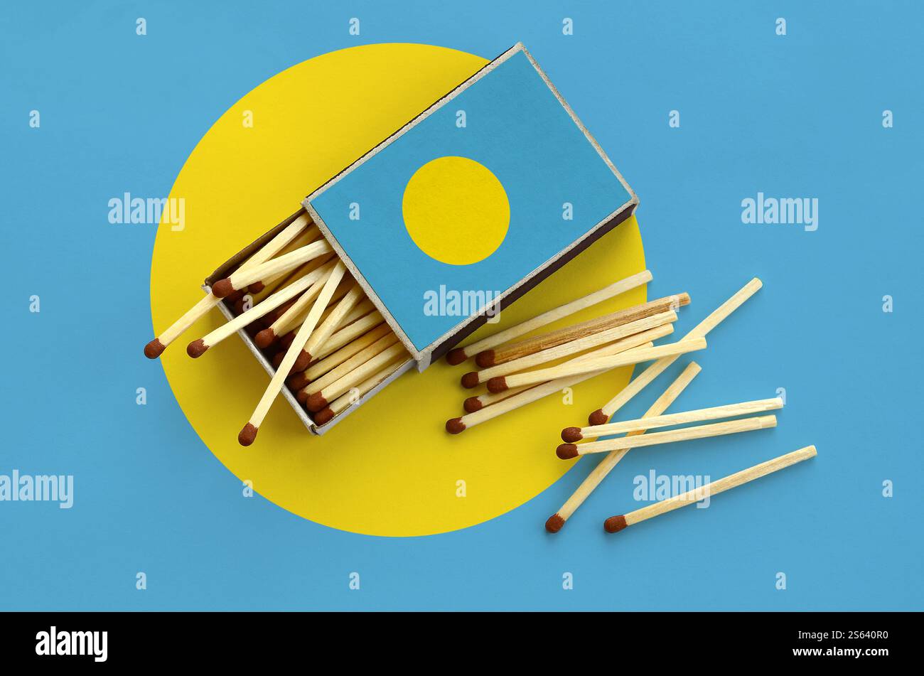 La bandiera di Palau è mostrata su una scatola aperta, da cui cadono diverse partite e giace su una grande bandiera. La bandiera Palau è visualizzata su una scatola di fiammiferi aperta, da Foto Stock