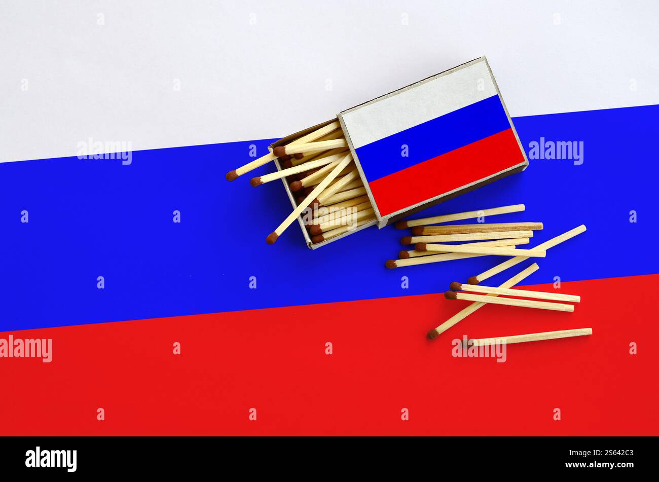 La bandiera della Russia è mostrata su una scatola aperta, da cui cadono diverse partite e giace su una grande bandiera. La bandiera della Russia è mostrata su una scatola di fiammiferi aperta, da Foto Stock