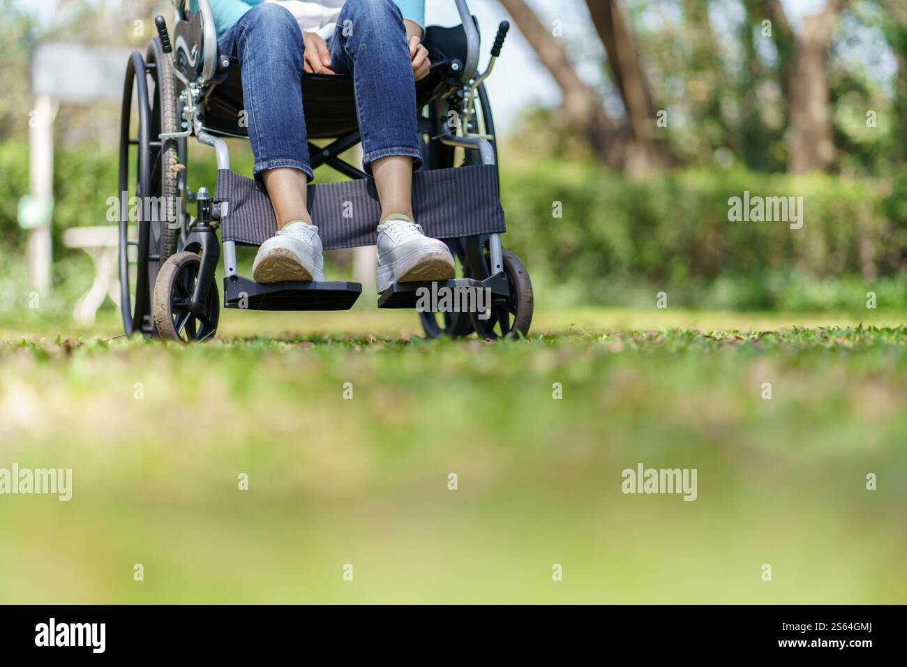 Giovane donna asiatica in sedia a rotelle con pensiero positivo Foto Stock