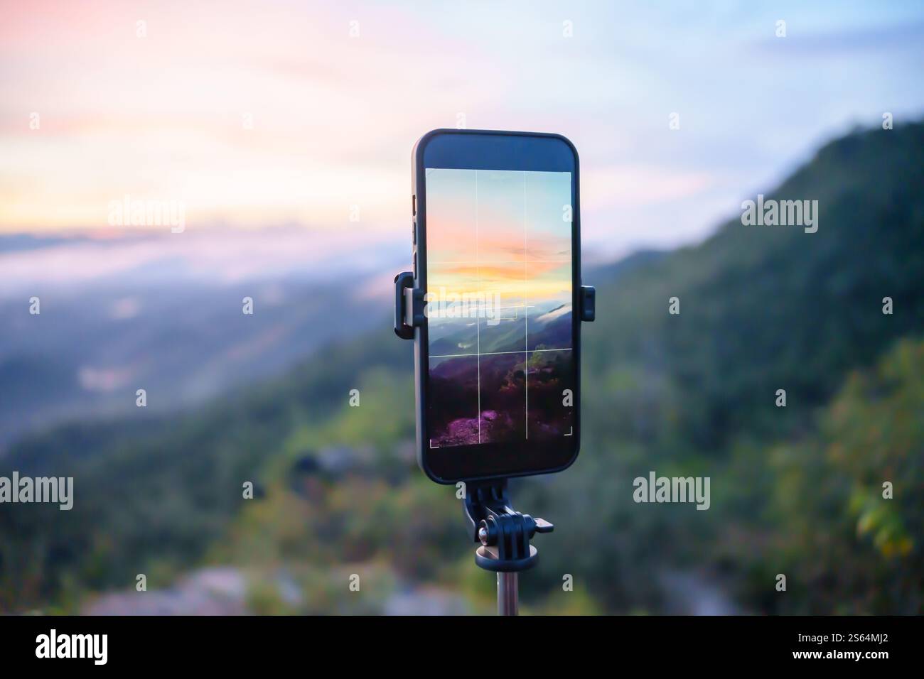 Smartphone che scatta foto del ruscello di montagna con la vista della natura del treppiede sullo schermo al tramonto. Foto Stock