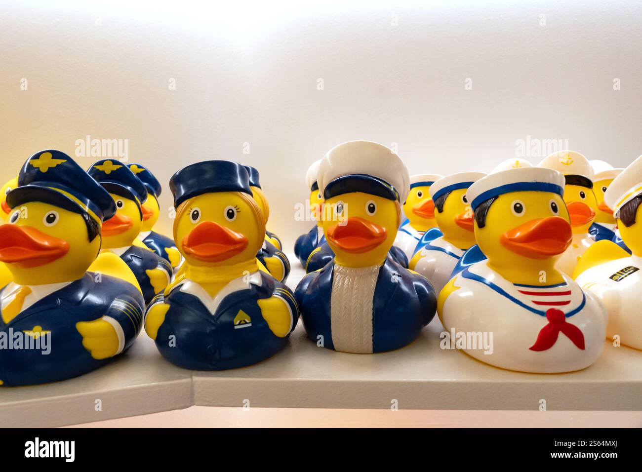 Varie anatre giocattolo di gomma gialle su uno scaffale in un negozio che vende come regalo Foto Stock