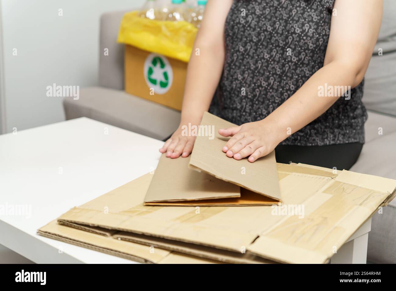 Riciclo domestico eco-zero rifiuti concetto donna che utilizza una scatola di carta riciclabile. Scatola di cartone marrone impilabile confezione ecologica in materiale grezzo riciclabile Foto Stock