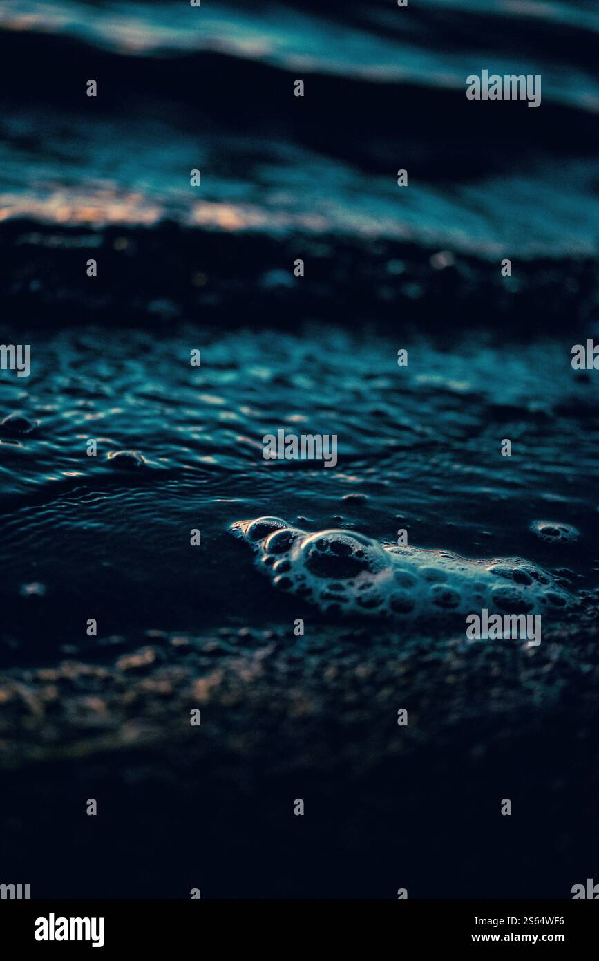 l'acqua sul bordo della spiaggia riflette la luce Foto Stock