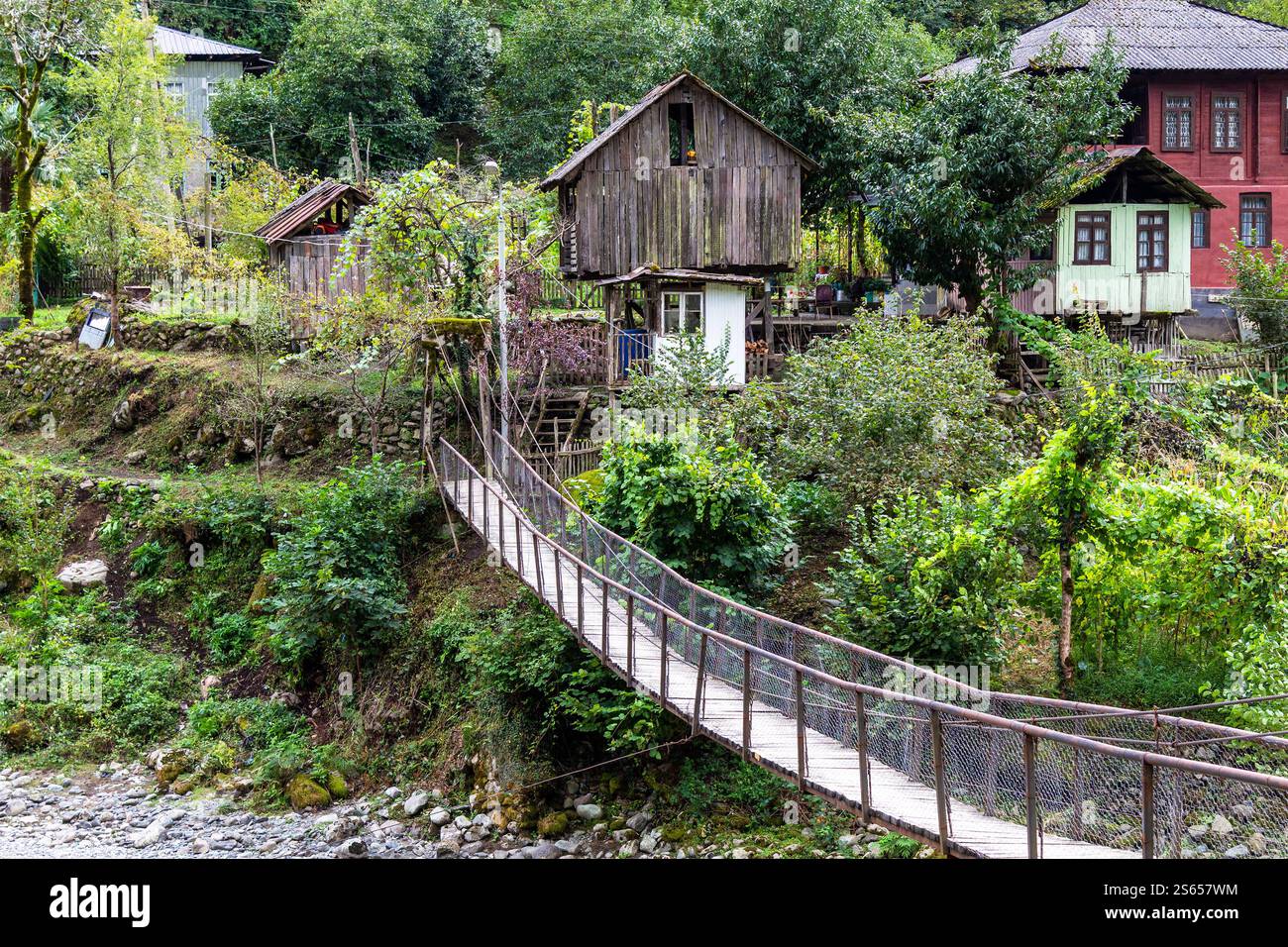 Viaggio in Georgia - ponte sospeso con pavimento in legno nel villaggio di Scurdidi sopra il fiume Scurdidi in Adjara il giorno d'autunno Foto Stock