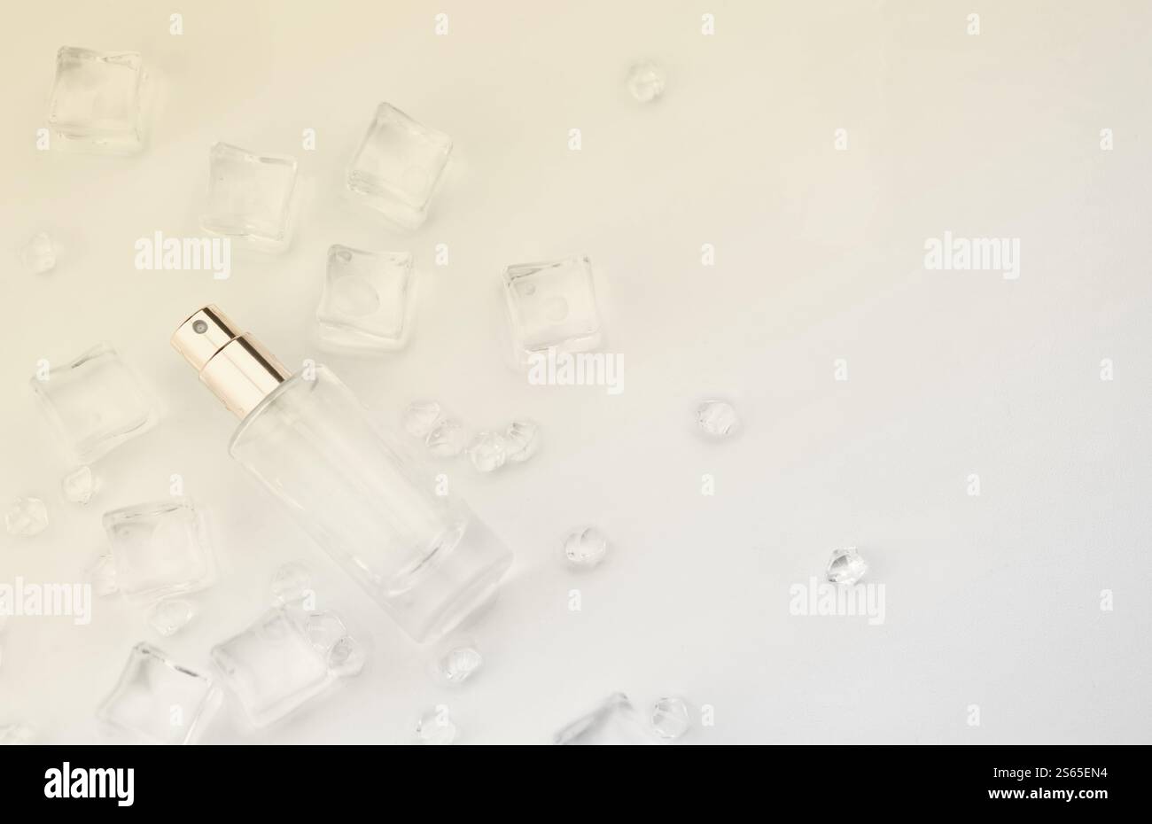 Bottiglia di profumo femminile, fotografia oggettiva della bottiglia di profumo in cubetti di ghiaccio e acqua. vista dall'alto. foto del prodotto, concetto di freschezza e aroma. Foto Stock