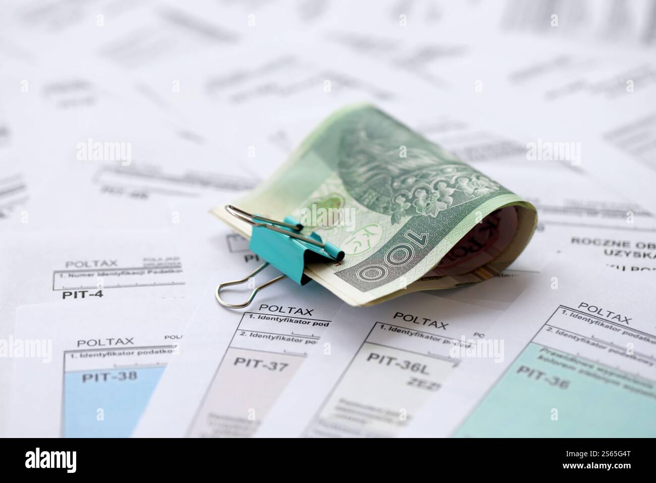 Soldi zloty polacchi PLN su una grande quantità di PIT polacco, CIT e moduli fiscali IVA da vicino. La contabilità, la burocrazia e la routine dei contribuenti in Polonia. Polacco Foto Stock