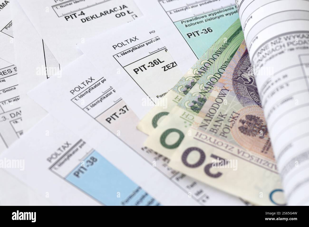Soldi zloty polacchi PLN su una grande quantità di PIT polacco, CIT e moduli fiscali IVA da vicino. La contabilità, la burocrazia e la routine dei contribuenti in Polonia. Polacco Foto Stock
