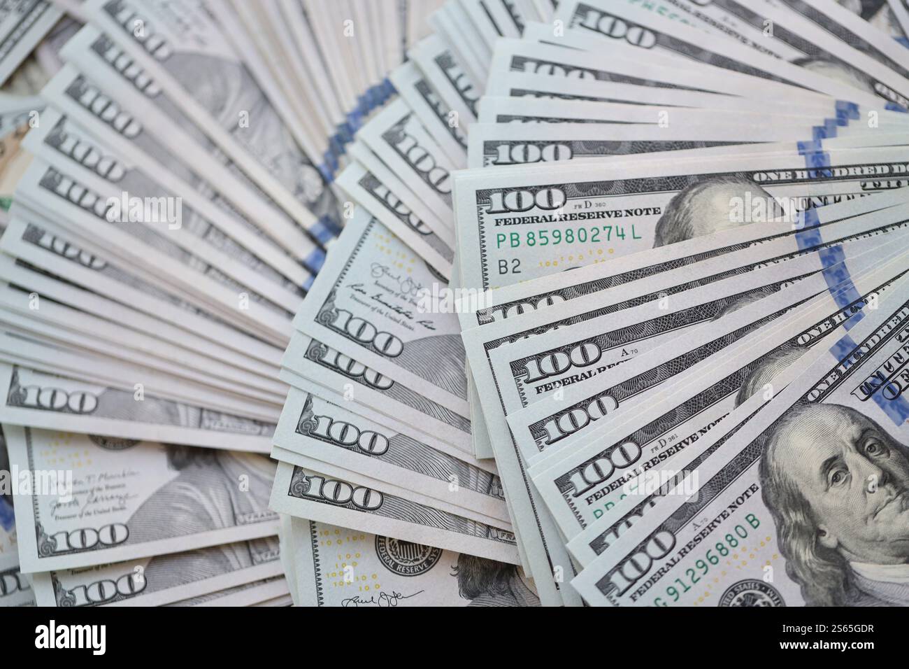 Un grosso ammontare di banconote da cento dollari da chiudere. Un'enorme quantità di banconote statunitensi su una tavola piatta. Un numero molto elevato di cento dollari Foto Stock
