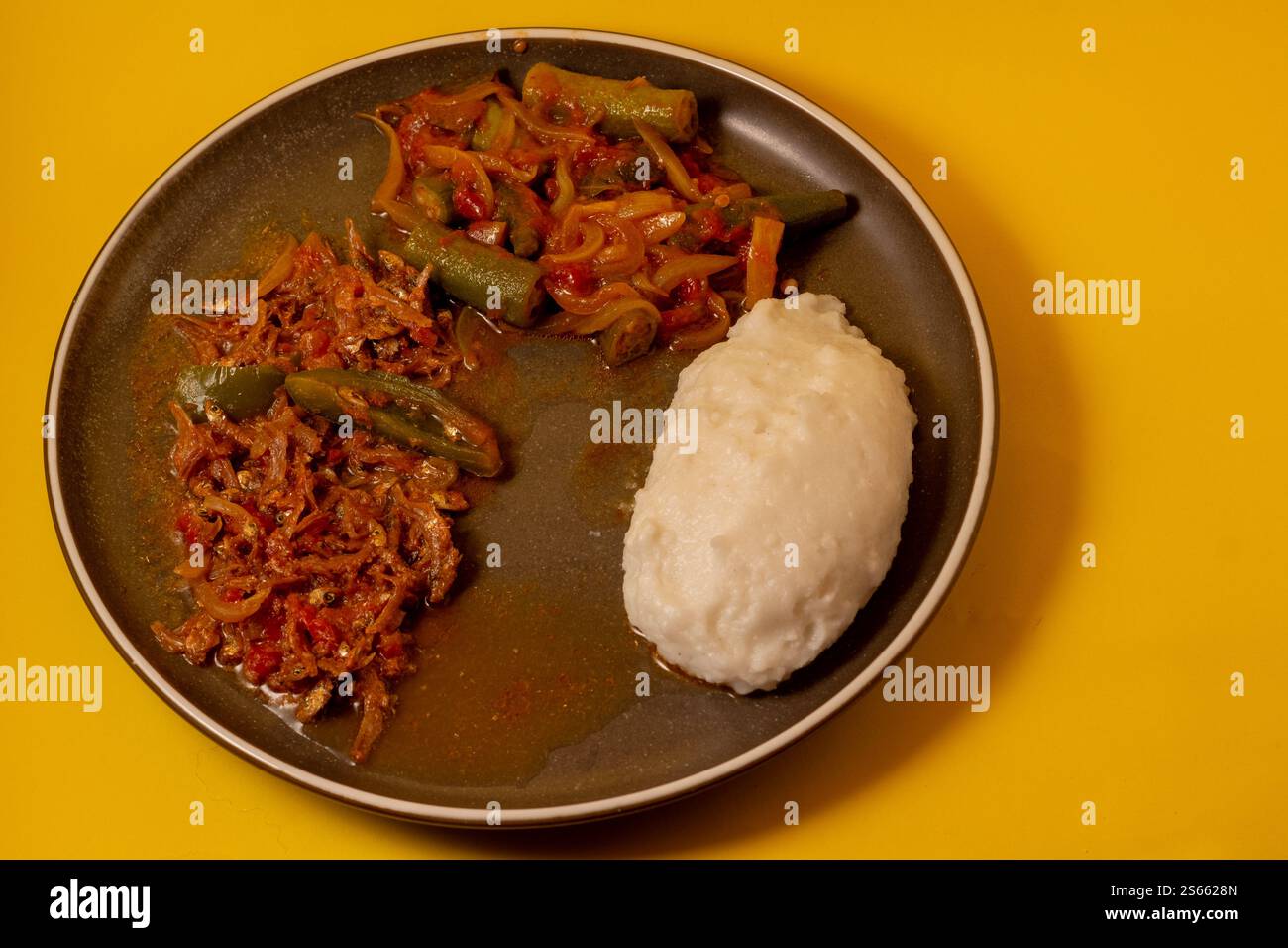 Matemba o Kapenta Fish (Limnothrissa miodon, Lake Tanganyika Sardine) e okra Stew servito con pasta di mais Foto Stock