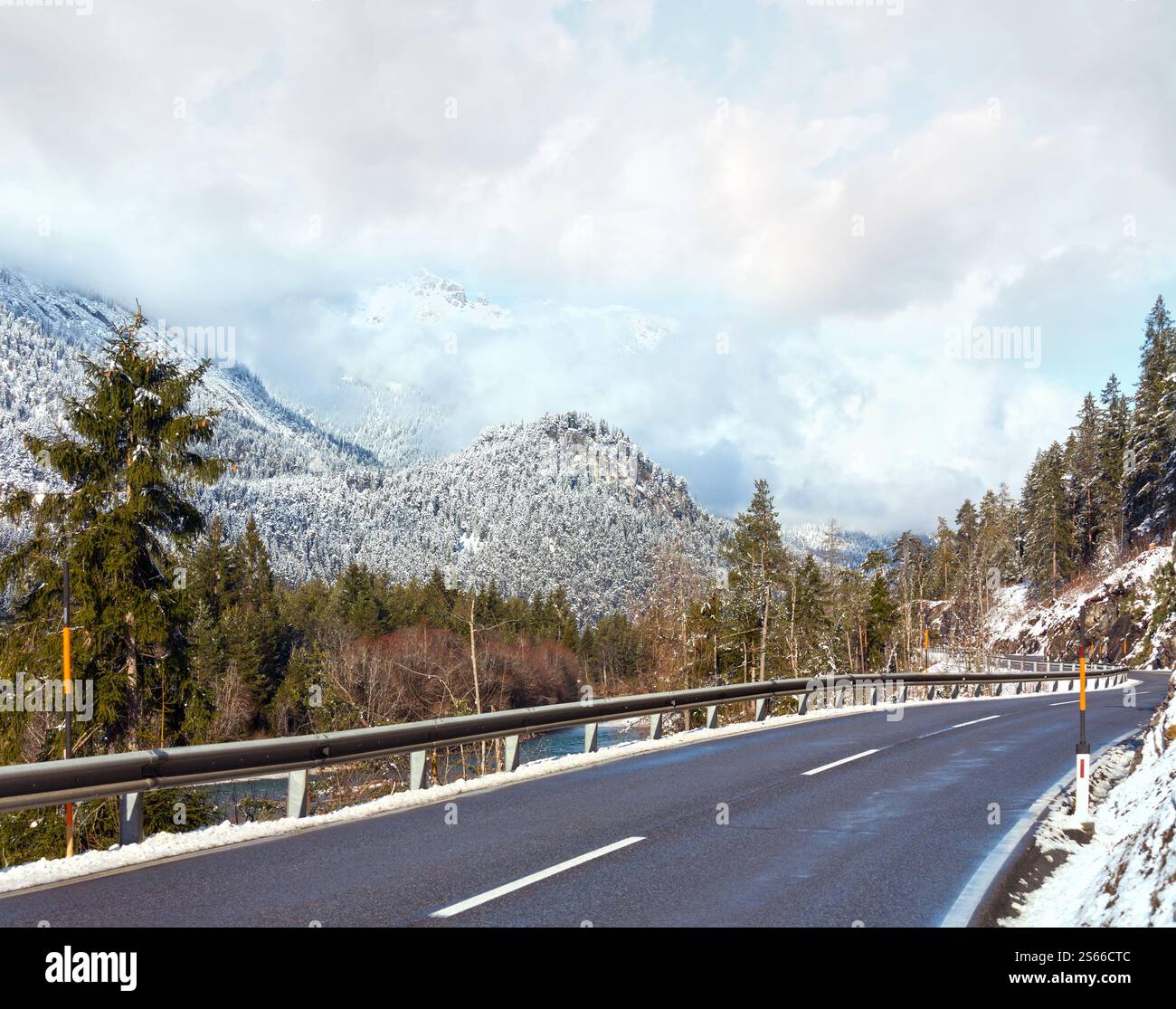 La strada lungo il fiume e coperto di neve e piste di montagna (Austria, Tirolo). Foto Stock