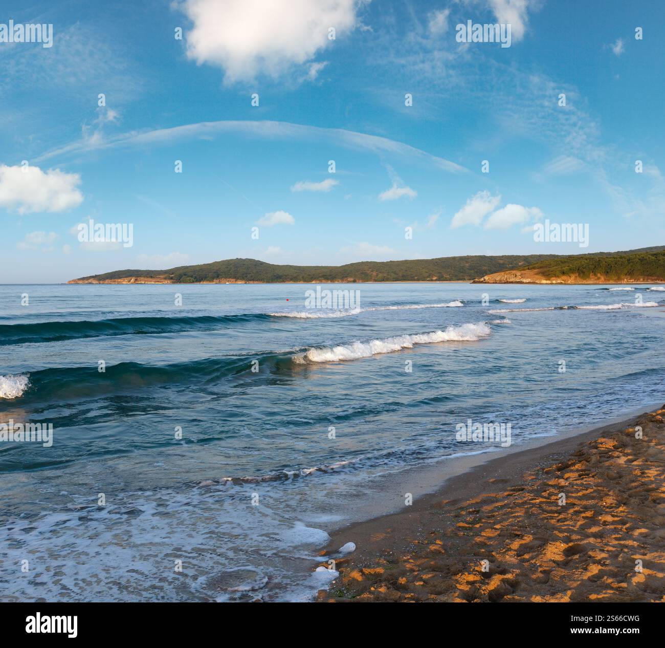 Bella costa del mare vista serale da spiaggia con onde da surf e sun la riflessione sulla sabbia. Foto Stock