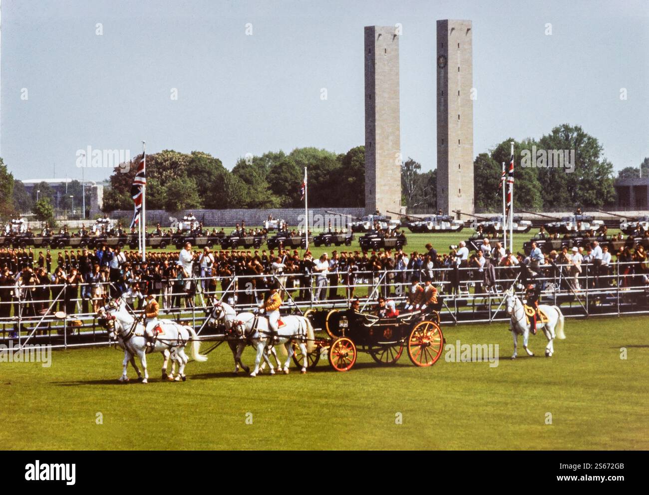 Berlino, Germania. 24 maggio 1985. Il monarca britannico la regina Elisabetta II, il principe Filippo e il principe Edoardo seduti in una carrozza reale aperta durante la loro visita di stato a Berlino il 24 maggio 1985. La carrozza è trainata da cavalli e lo Stadio Olimpico è visibile sullo sfondo. L'immagine cattura un momento dell'apparizione della famiglia reale davanti alla folla durante questa importante visita di stato in Germania. La visita avvenne in un momento in cui la Germania era ancora un paese diviso durante la guerra fredda. Foto Stock