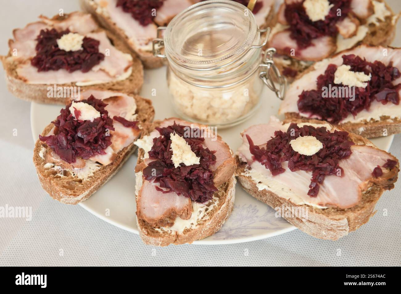 Foto con messa a fuoco selettiva. Pane ciabatta con carne secca, cavolo rosso sottaceto e rafano. Foto Stock