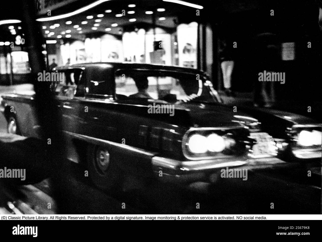 Negli anni '1960 Un'auto d'epoca americana in strada di notte. Un modo per divertirsi persone interessate a auto d'epoca, appassionati, spesso percorrono le strade di notte per puro divertimento e socializzazione. L'attività è chiamata crociera, caratterizzata da un viaggio impulsivamente casuale e spesso senza meta con l'auto. 1964 Foto Stock