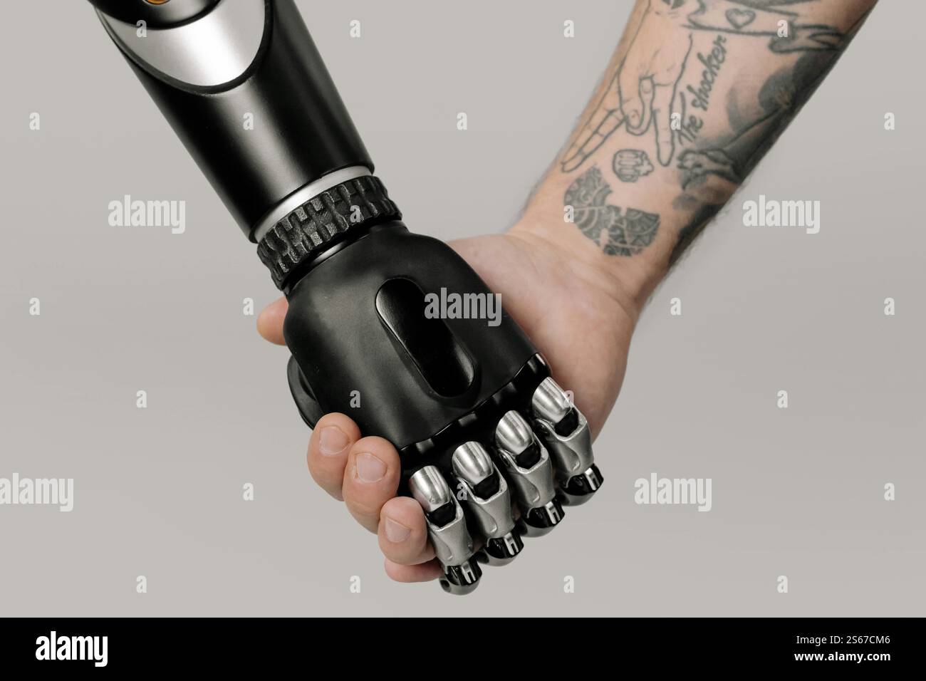 un robot e un umano che si tengono per mano Foto Stock