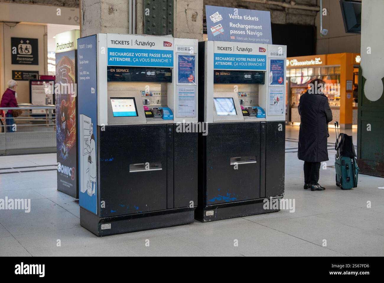 Distributori automatici di biglietti presso una stazione ferroviaria affollata in città durante il giorno Foto Stock