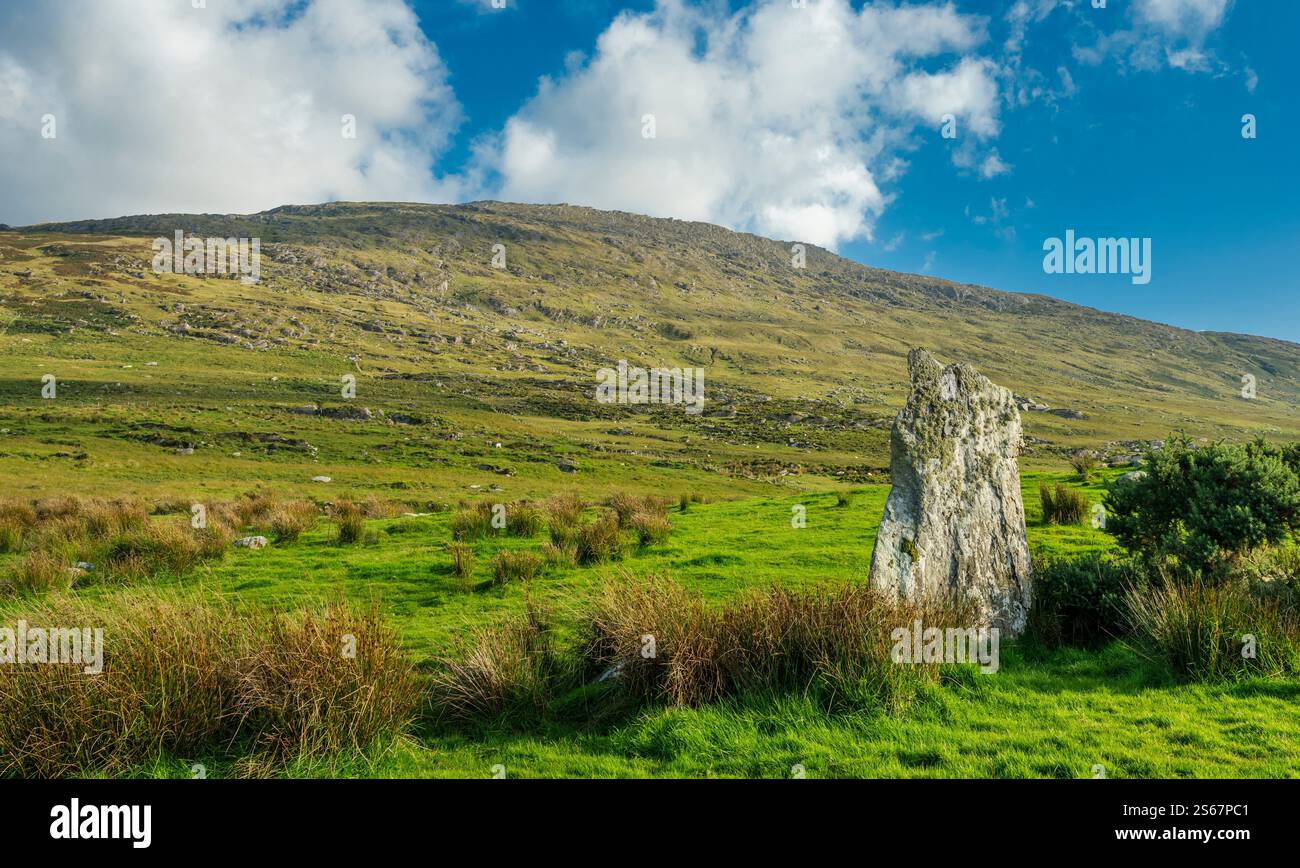 Una pietra in piedi vicino all'ingresso del cerchio di pietre vicino ad Ardgroom, la Penisola di Beara, la Contea di Cork, con la montagna di Tooreennamna sullo sfondo Foto Stock