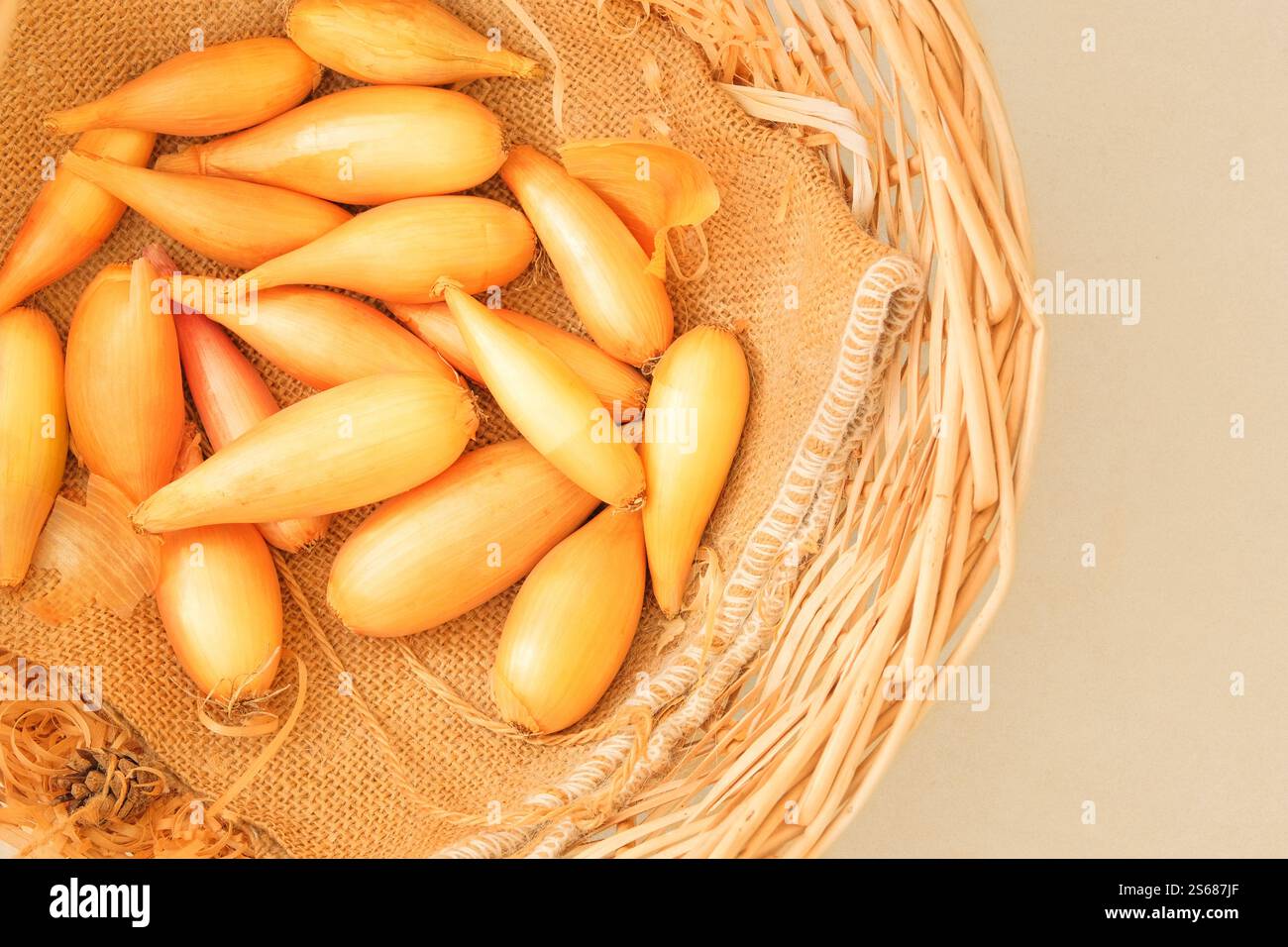Cipolla in un cestello di paglia. Scalogno maturo all'arancia. Verdure dall'odore e dal sapore forti. Vista dall'alto. Posiziona per testo. Foto Stock