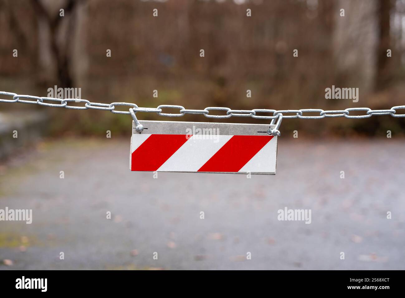 Vista di un cartello a strisce diagonali rosso e bianco appeso su una catena Foto Stock