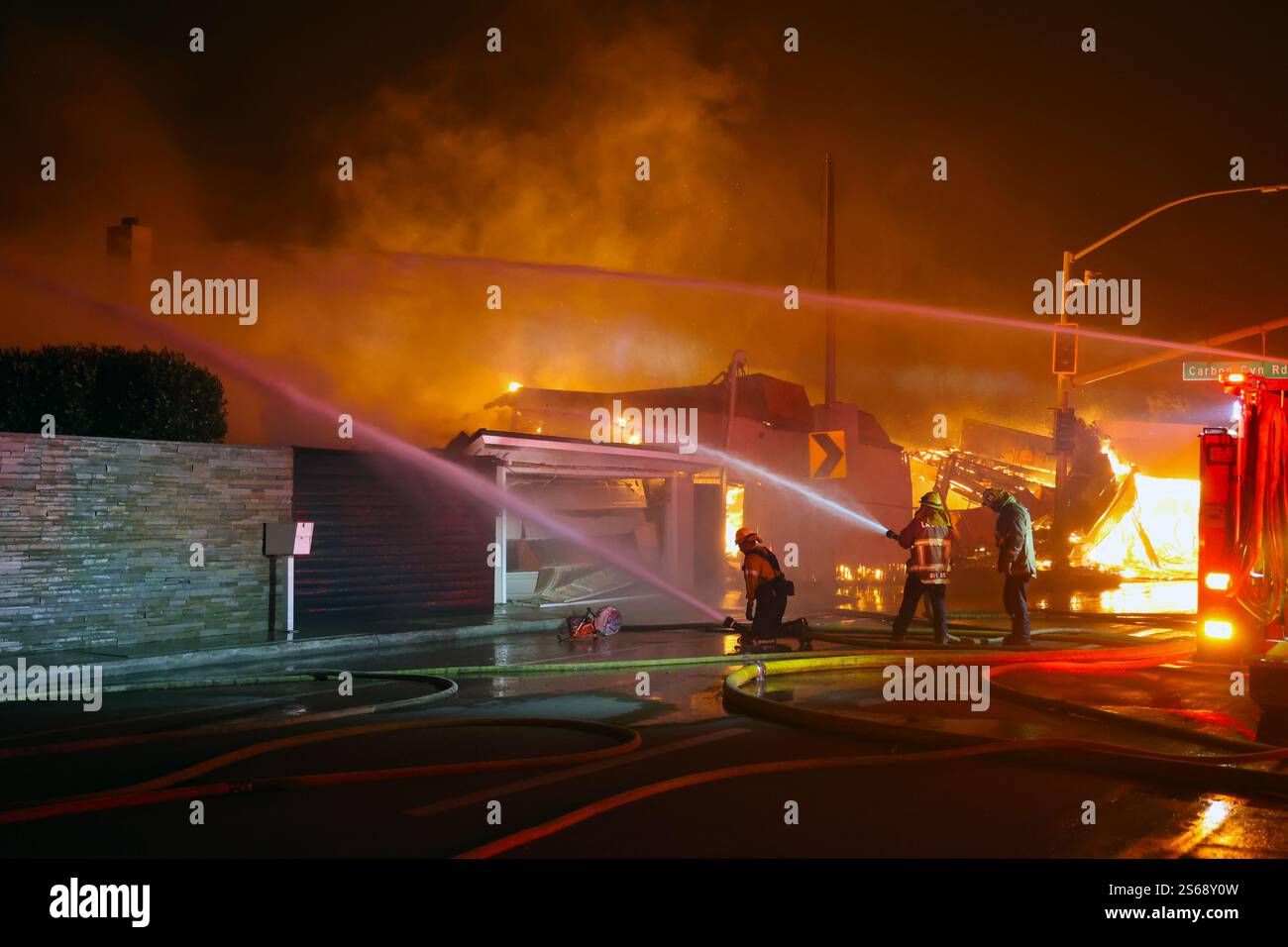 PACIFIC PALISADES, LOS ANGELES, CALIFORNIA, USA - 8 gennaio 2025 - i vigili del fuoco affrontano un edificio in fiamme nella zona di Pacific Palisades in California Foto Stock