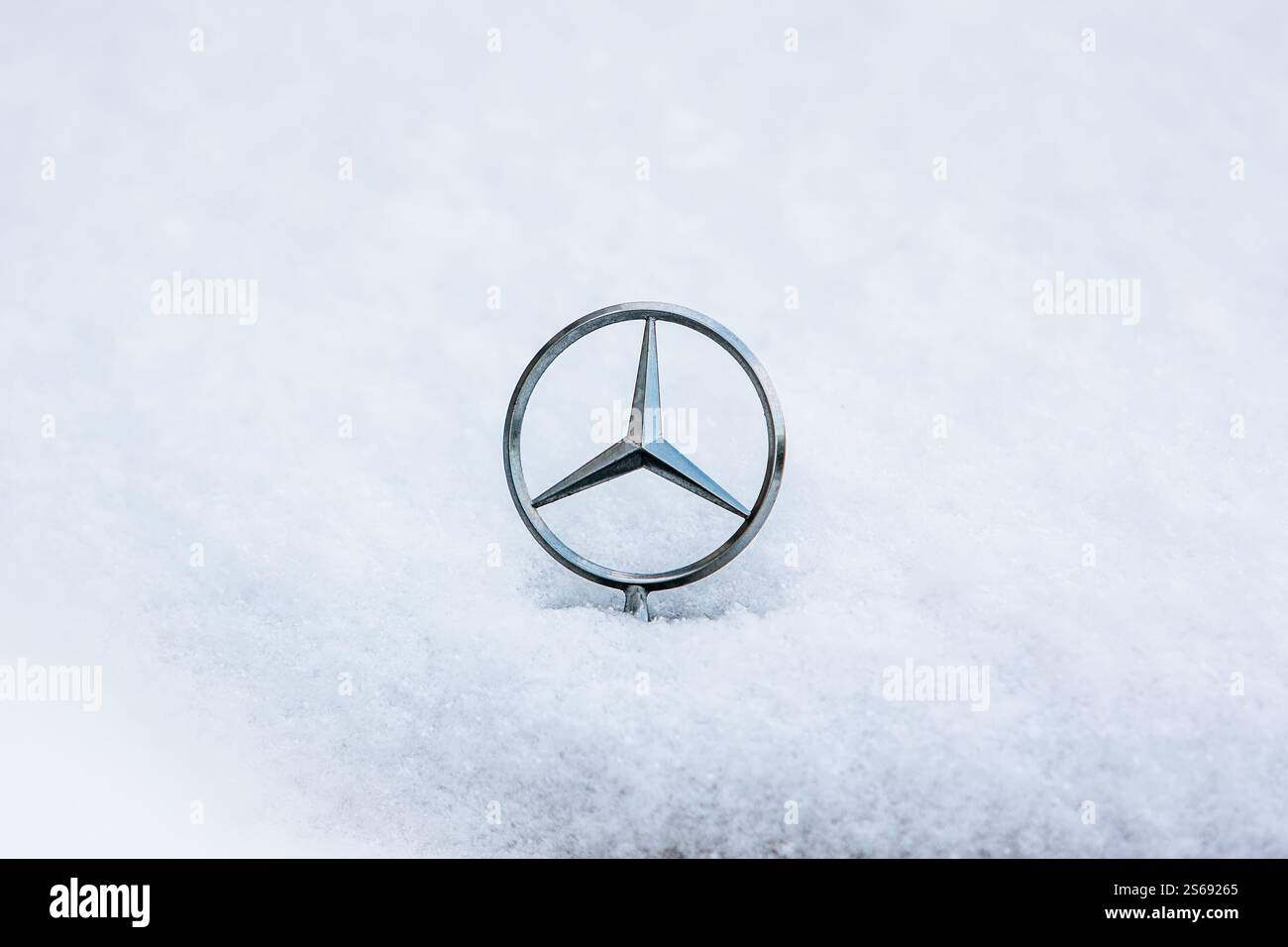 Un simbolo a stella del cofano / stella del cofano a tre punte Mercedes Benz è raffigurato sul cofano / cofano innevato di un'auto / automobile Mercedes Benz. Foto Stock