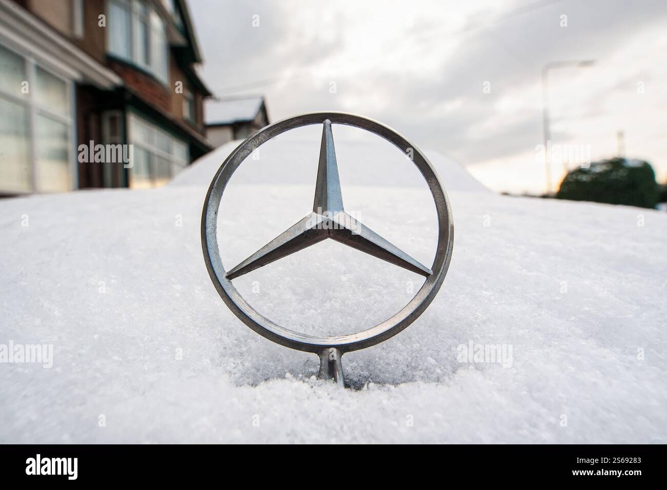 Un simbolo a stella del cofano / stella del cofano a tre punte Mercedes Benz è raffigurato sul cofano / cofano innevato di un'auto / automobile Mercedes Benz Foto Stock