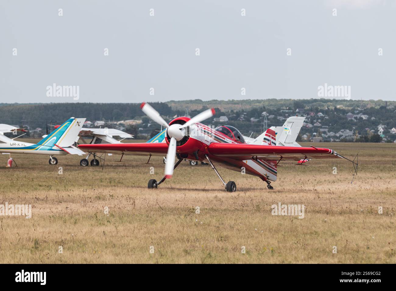 Charkiv, Ucraina - 29 agosto 2021: Velivolo su-31 rosso atterra dopo l'aerobatica sul campo di aviazione in erba della pista di KharkivAviaFest Foto Stock