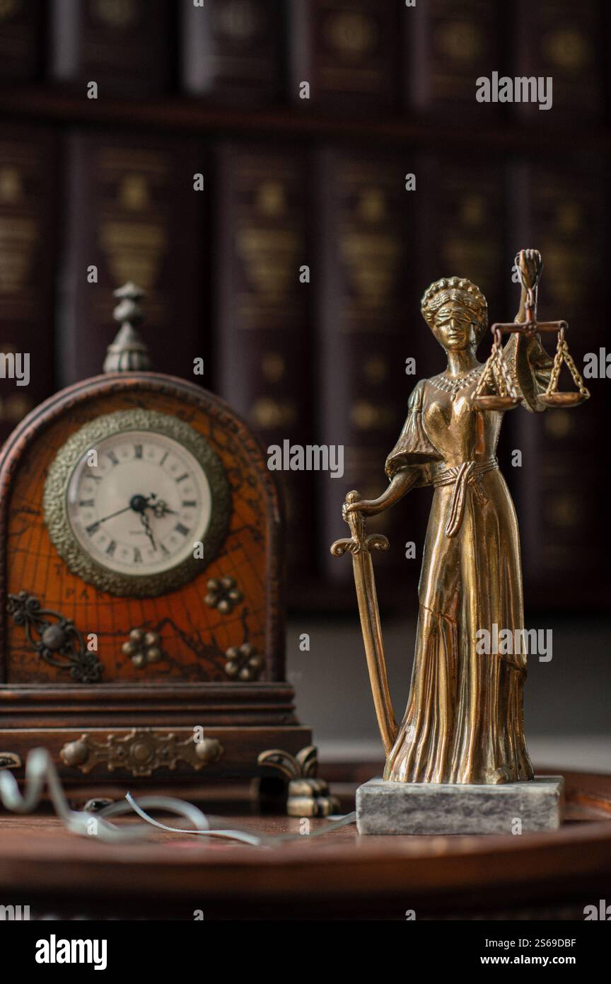 Uno studio legale con scaffali, orologi antichi e una statua della Lady Justice, che riflette la professionalità e la tradizione. Foto Stock