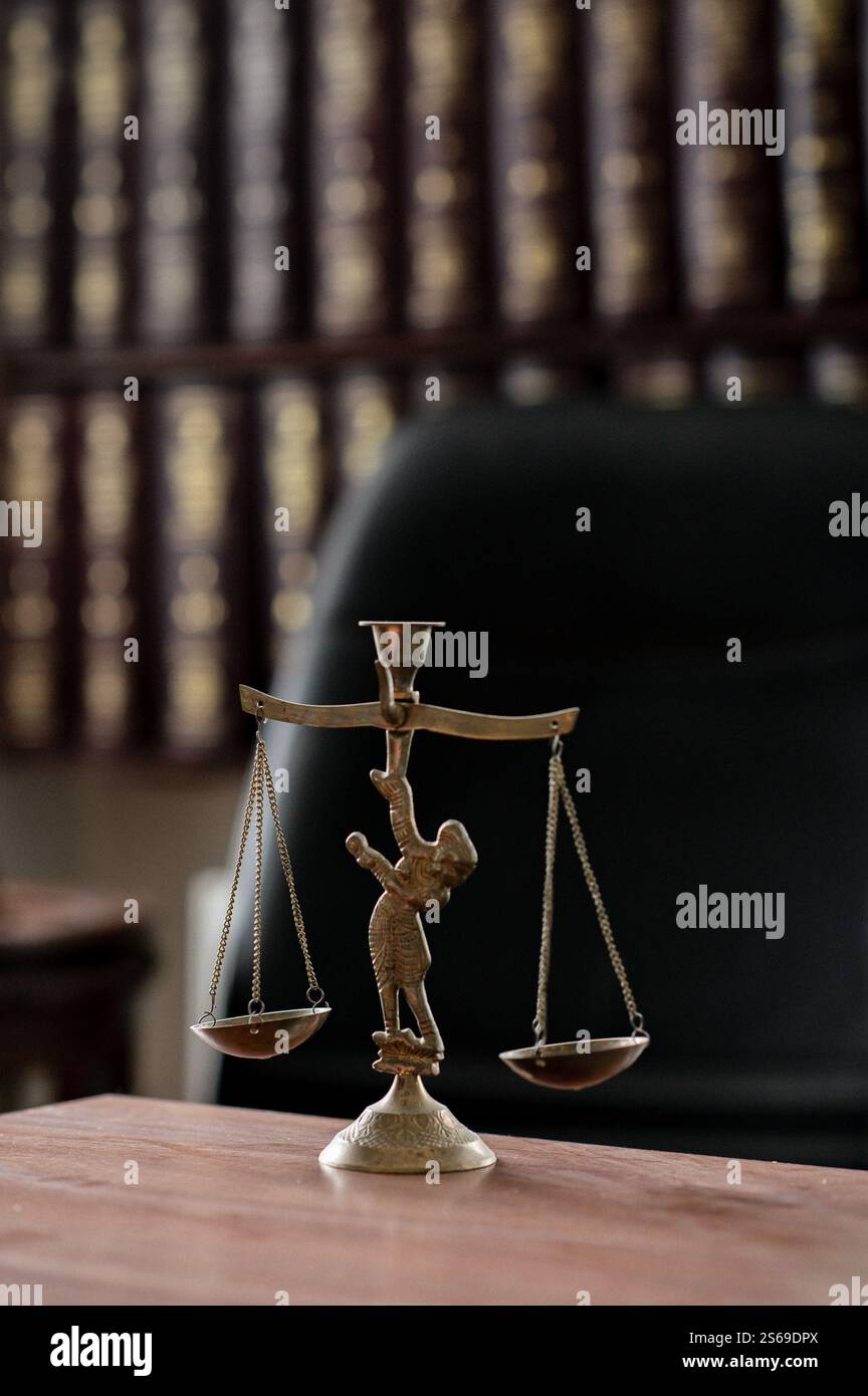 Uno studio legale con scaffali, orologi antichi e una statua della Lady Justice, che riflette la professionalità e la tradizione. Foto Stock