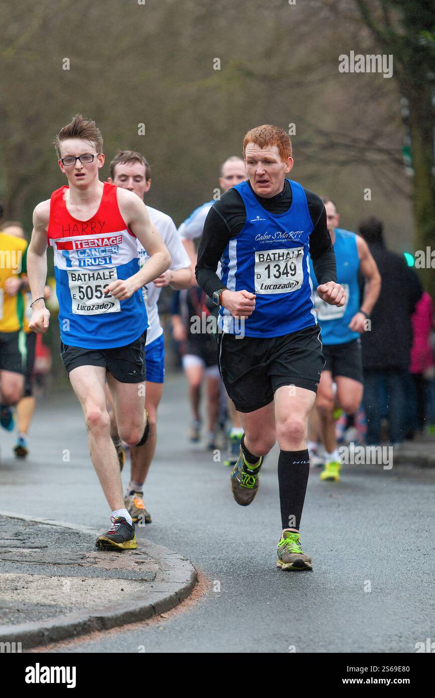 Gli atleti maschili che corrono e gareggiano nella corsa su strada della Bath Half Marathon vengono ritratti mentre corrono verso il traguardo. Foto Stock