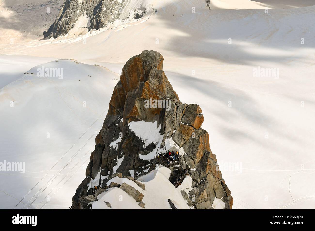 Vista sopraelevata della vetta le Pilastre presso la funivia Aiguille du Midi (3842 m), con escursionisti su una scala di metallo, Chamonix-Mont-Blanc, alta Savoia, Francia Foto Stock