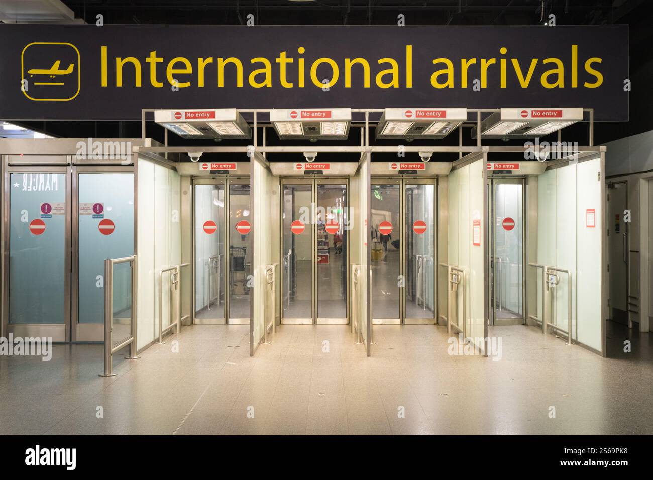I passeggeri passano attraverso i cancelli di uscita automatici degli arrivi dell'aeroporto internazionale di Gatwick, Inghilterra, Regno Unito Foto Stock
