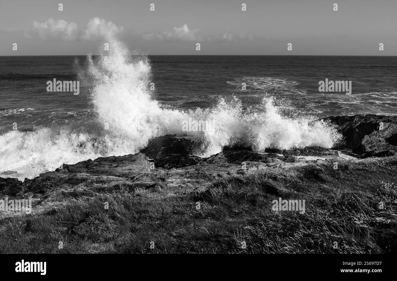 Potenti onde che si infrangono sulle rocce della costa atlantica irlandese, in bianco e nero. Foto Stock