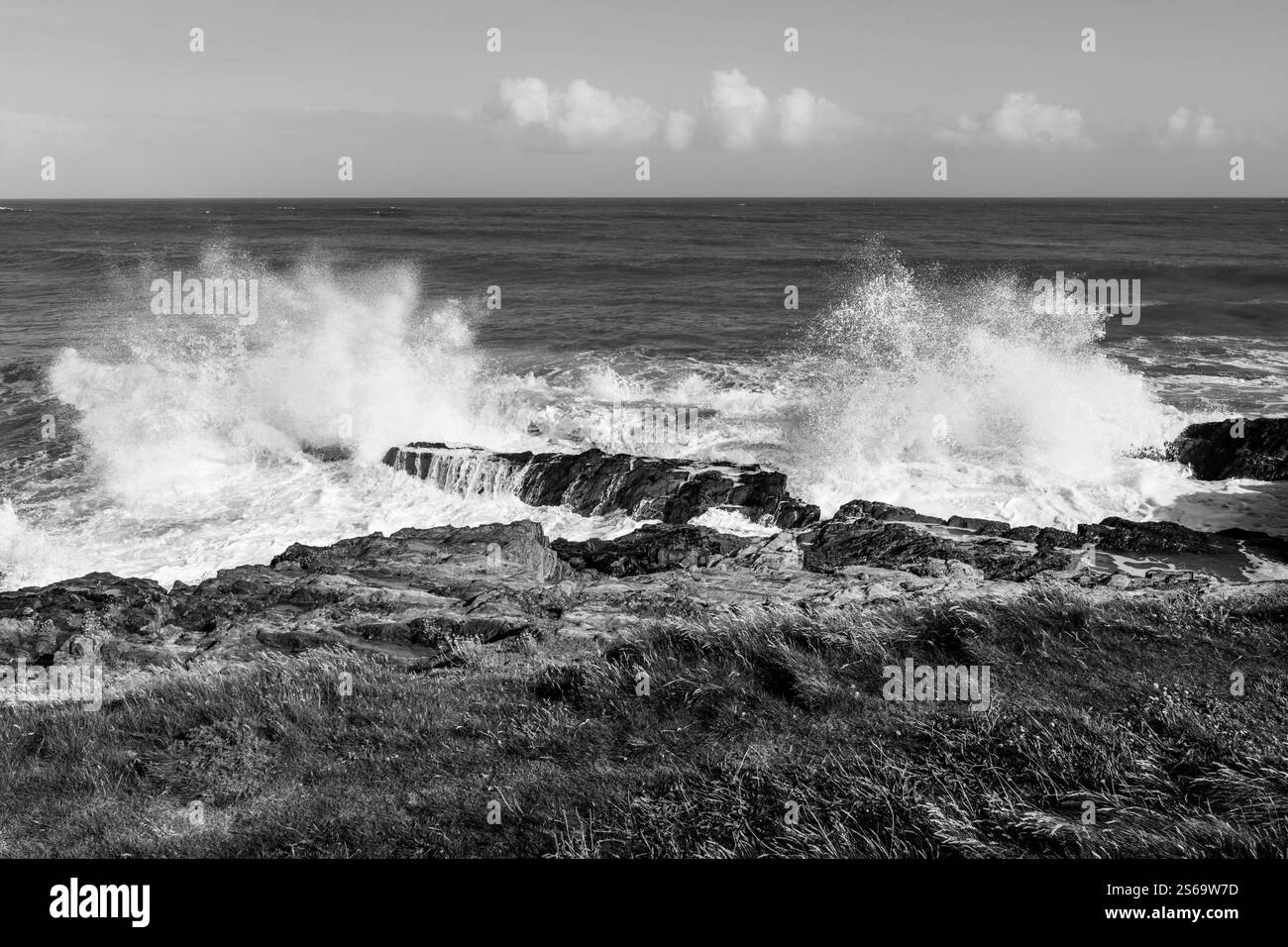 Potenti onde che si infrangono sulle rocce della costa atlantica irlandese, in bianco e nero. Foto Stock