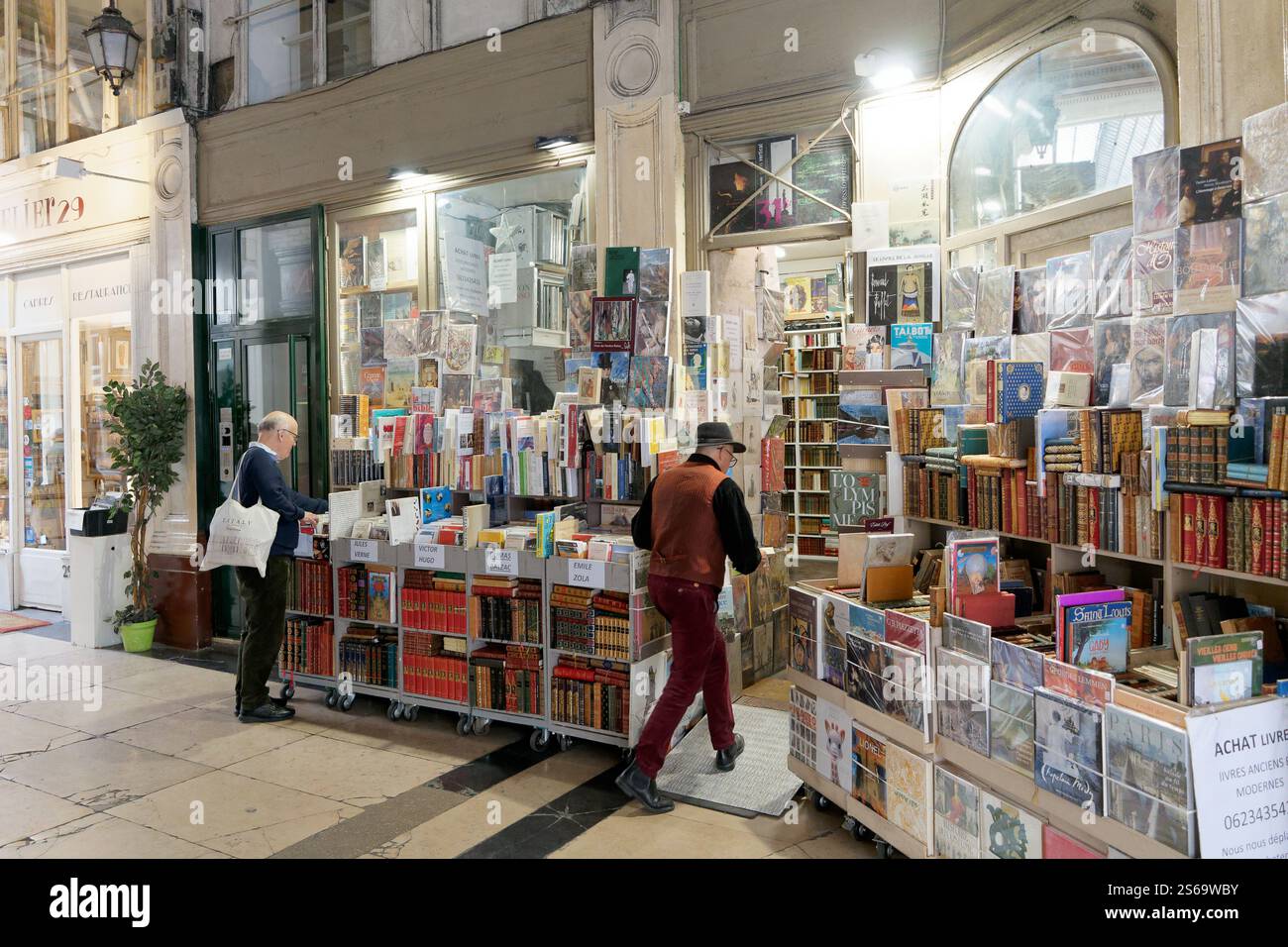 una libreria al coperto con numerosi scaffali e tavoli pieni di libri. Il negozio offre un'ampia varietà di libri, tra cui titoli vintage e moderni. Foto Stock