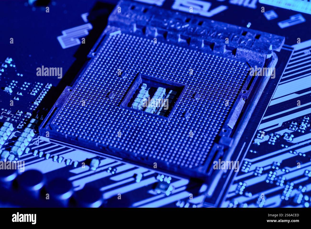 Primo piano di una presa per scheda madre sotto l'illuminazione blu, che mostra il design complesso e i componenti elettronici. Ideale per l'uso in articoli tecnici, pro Foto Stock