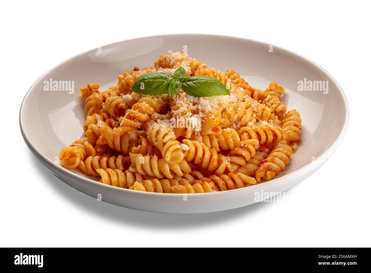 Fusilli con salsa di pomodoro e parmigiano grattugiato e foglie di basilico in piatto bianco isolato su bianco con percorso di ritaglio incluso Foto Stock