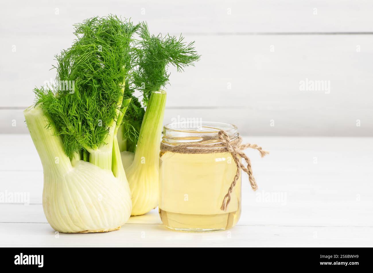 Bottiglia in vetro di olio essenziale di finocchio con semi di finocchio e bulbo su un tavolo di legno. Herbs medicina alternativa concetto di fondo Foto Stock