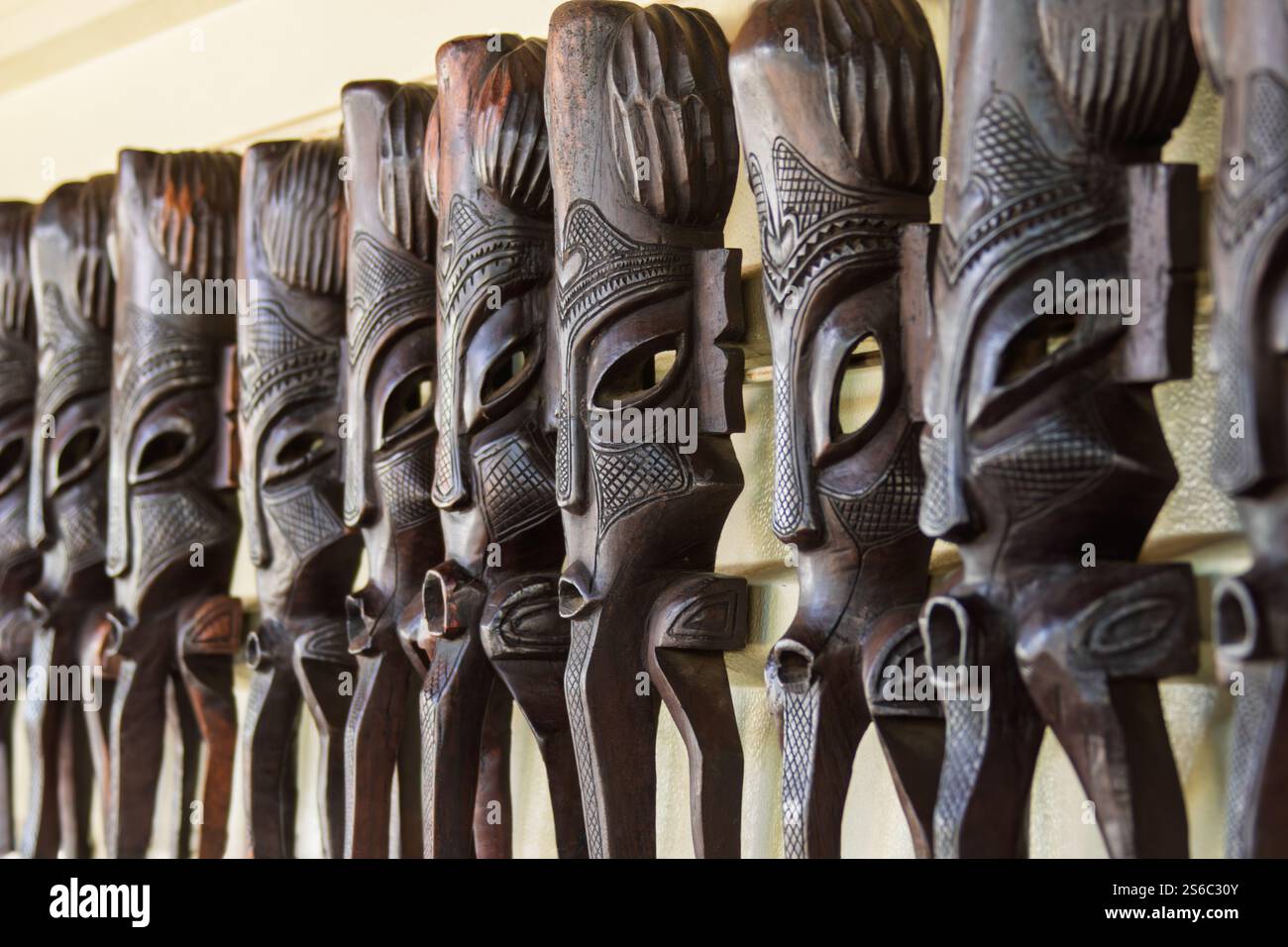 maschera africana in legno vintage, serie sul muro in un negozio di souvenir Foto Stock