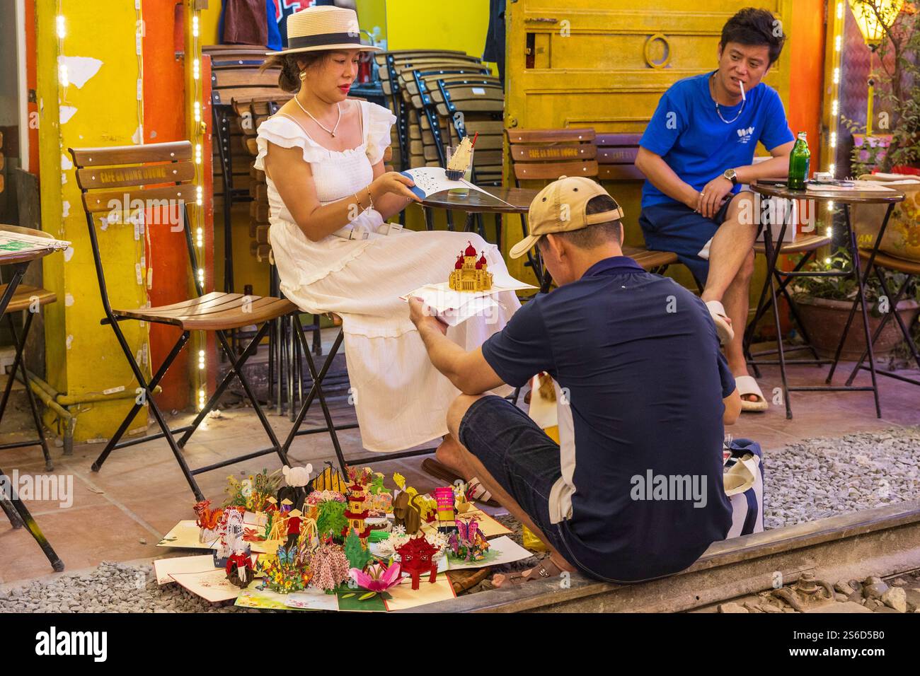 Un commerciante di strada con un cliente, via ferroviaria o via ferroviaria di Đường Phùng Hưng, quartiere vecchio, Hanoi, Vietnam, venerdì, 1 novembre 2024. Foto Stock
