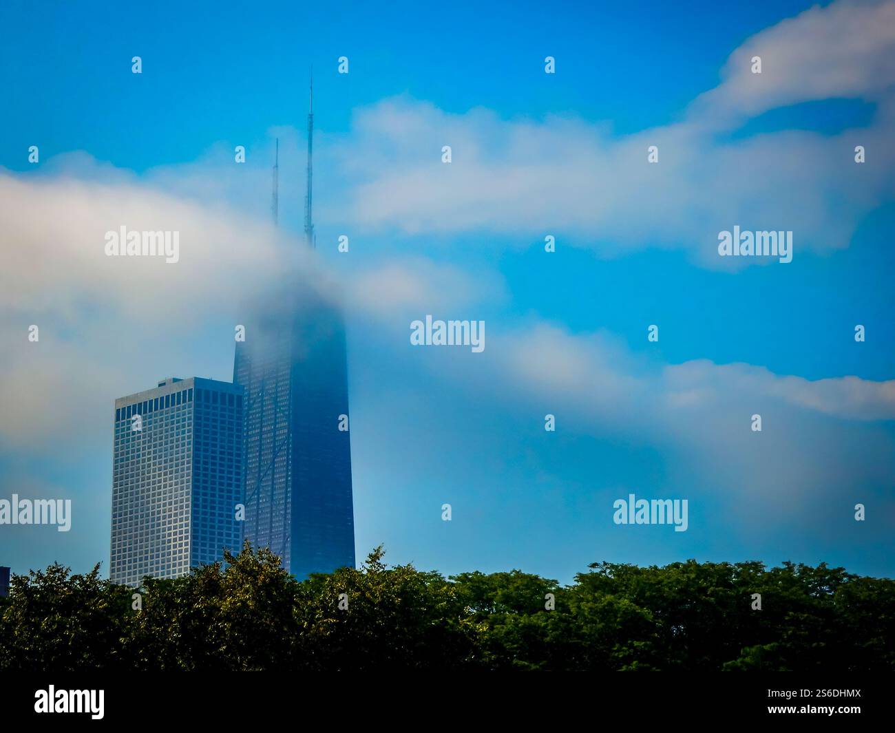 Il John Hancock Building emerge attraverso morbide e ondulate nuvole sopra un lussureggiante profilo, mescolando l'architettura iconica di Chicago con l'atmosfera del lago Michigan. Foto Stock